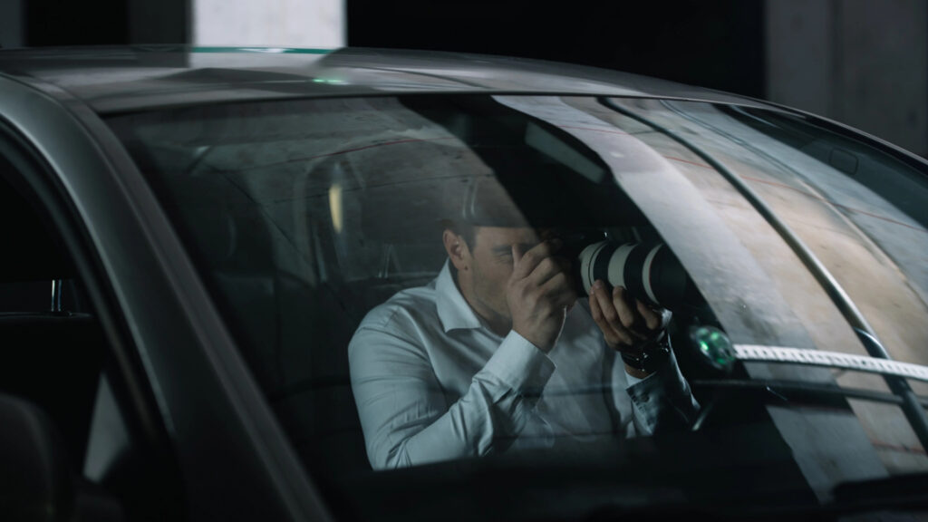 surveillance investigator Oklahoma conducting covert observation from inside vehicle using camera